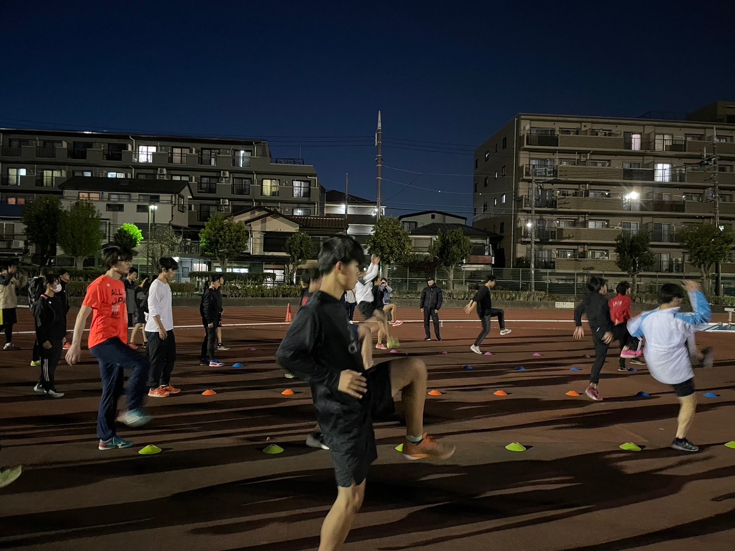 夜の陸上競技場で走りの技術練習に取り組むSPRINTEST陸上スクールの参加者